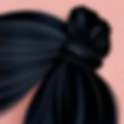 Close-up of a sleek black hair tie against a textured background.